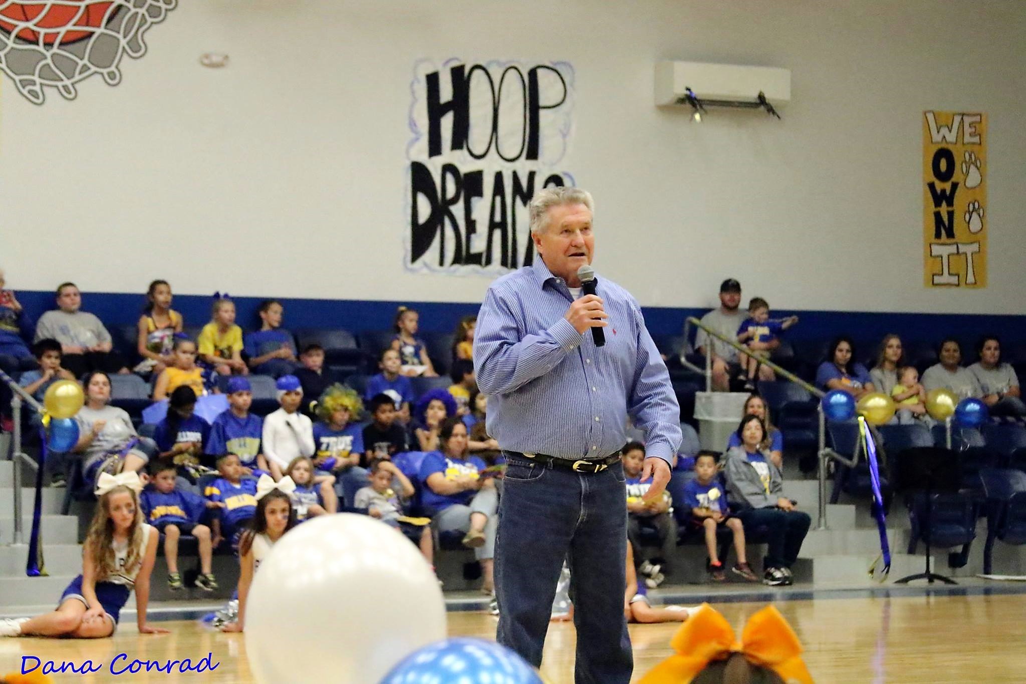 A teacher speaking up at the school's gym.