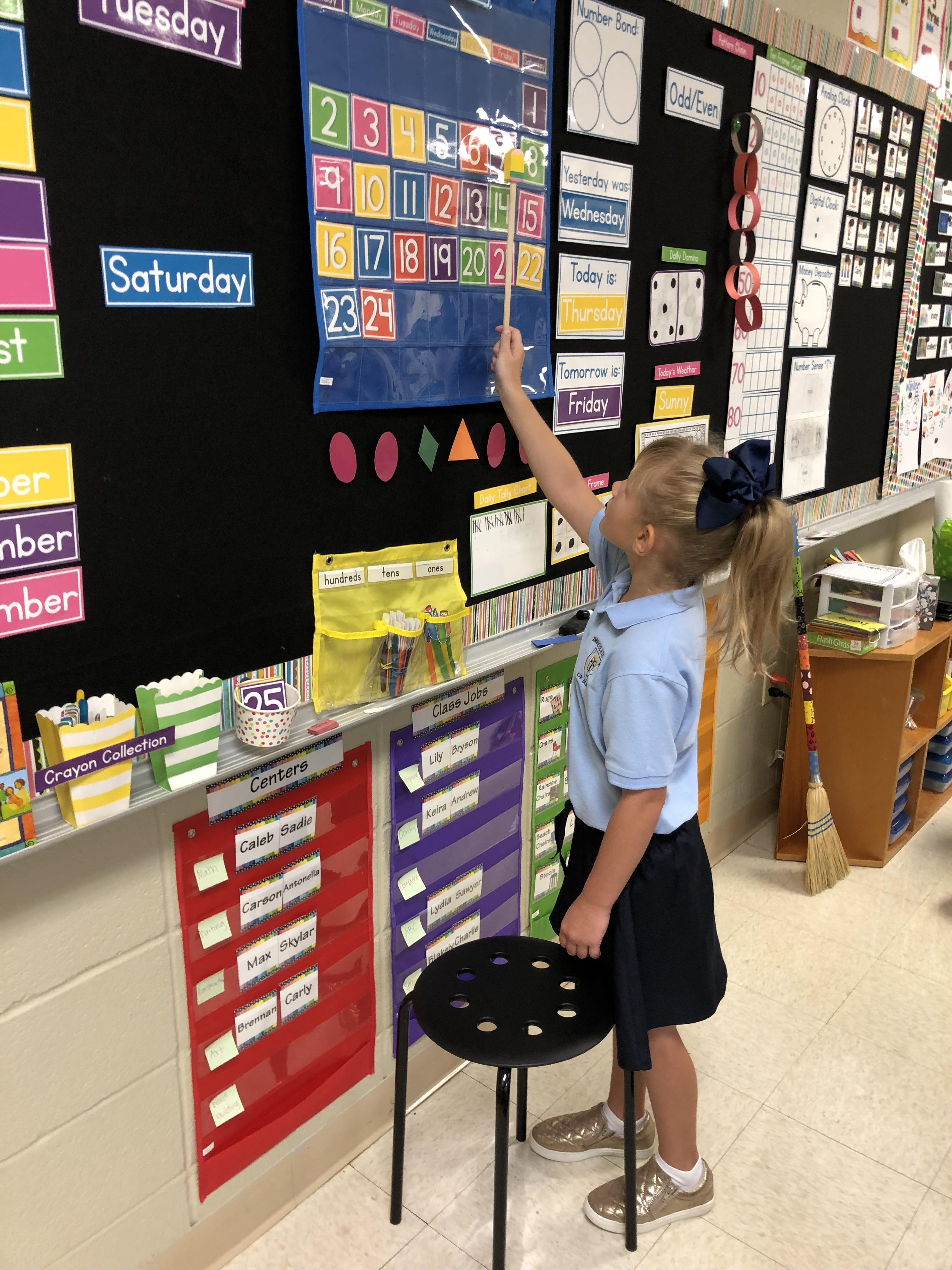 A girl rearranging the numbers on a calendar