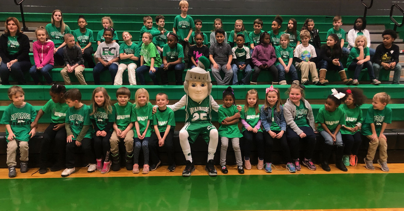 A photo of the School Mascot and some students in the gym.