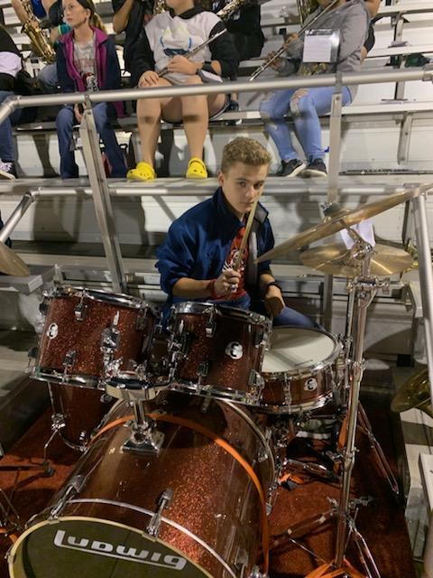 Another student with a set of drums along with the orchestra club.