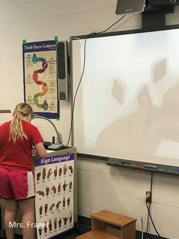 A girl setting up the proyector for the class.