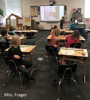 Students working on their homework with the help of a proyector.