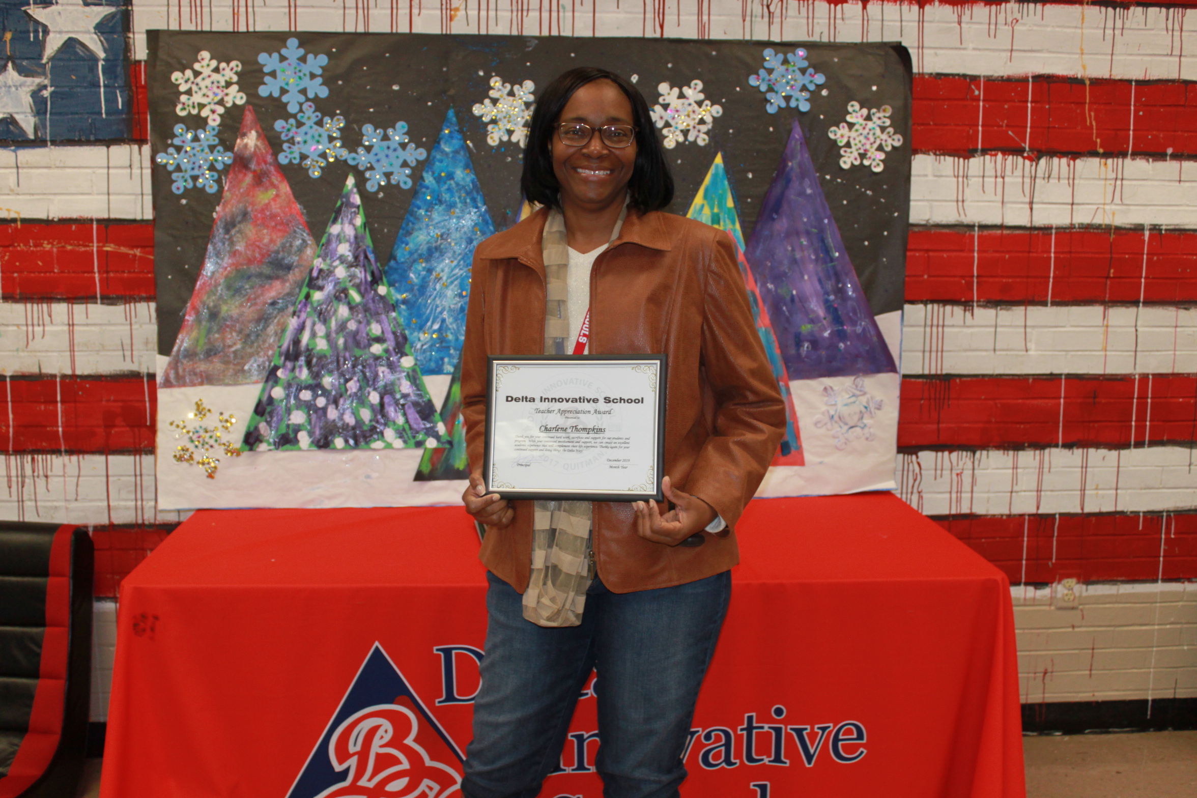 Photo of Teacher Thompkins with her Teacher of Quarter diploma.