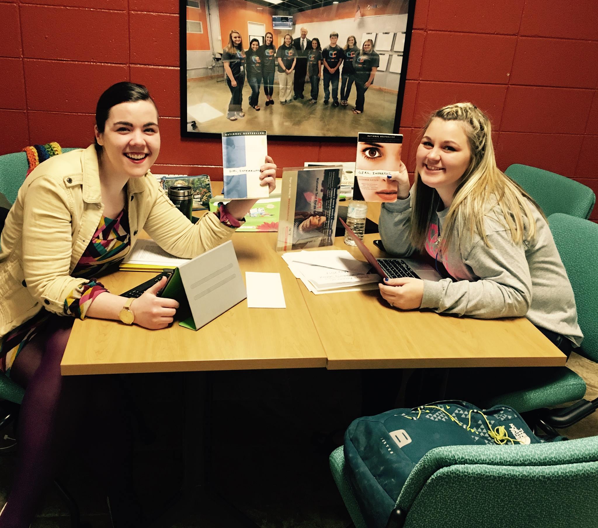Picture of students holding up books