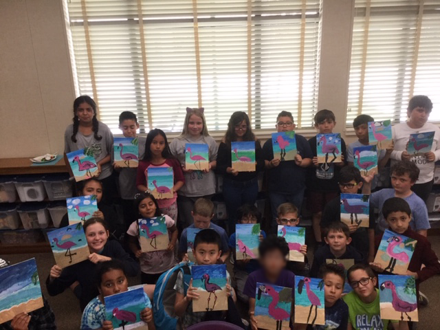 Photo of the students showing off their paintings