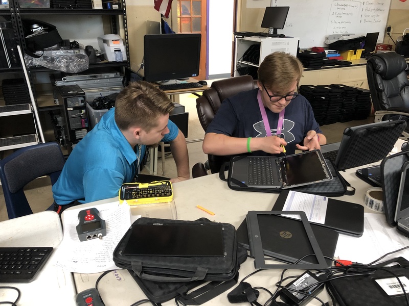Caleb Thurston replaces a laptop screen with Zach Burton.