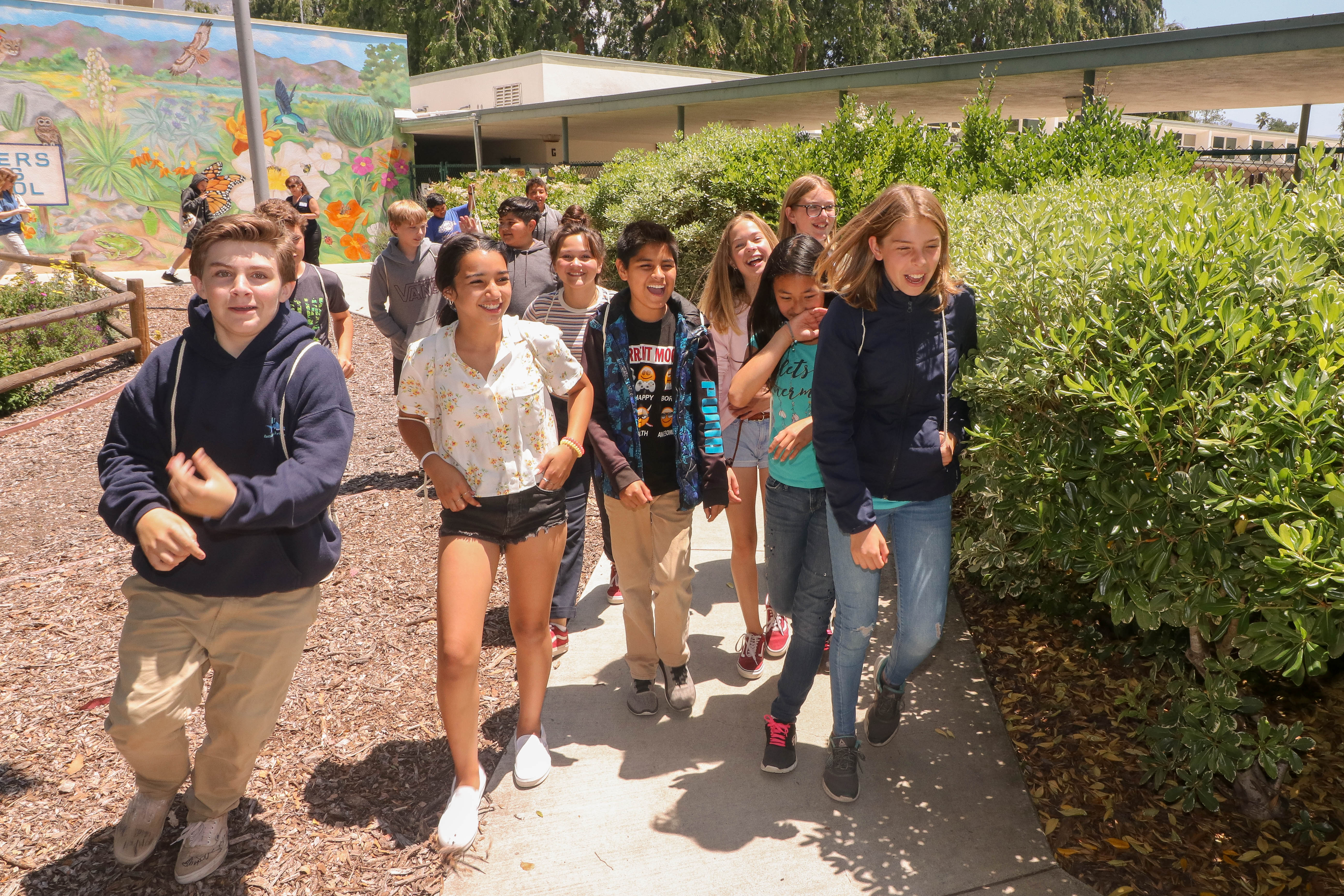 A group of kids walking around the school's orchard