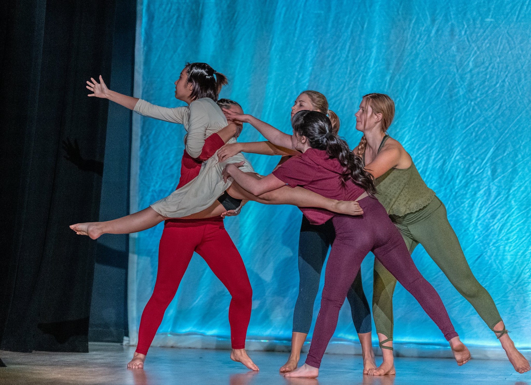 A girl jumping up, a group of girls holding her back and supporting her in the air