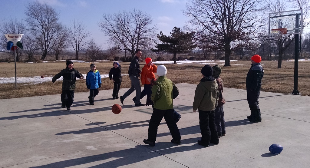 photo of students playing basketball outside