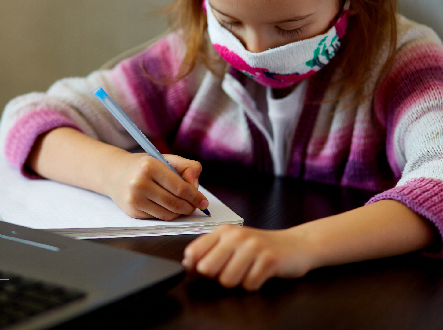 student wearing face mask working at desk