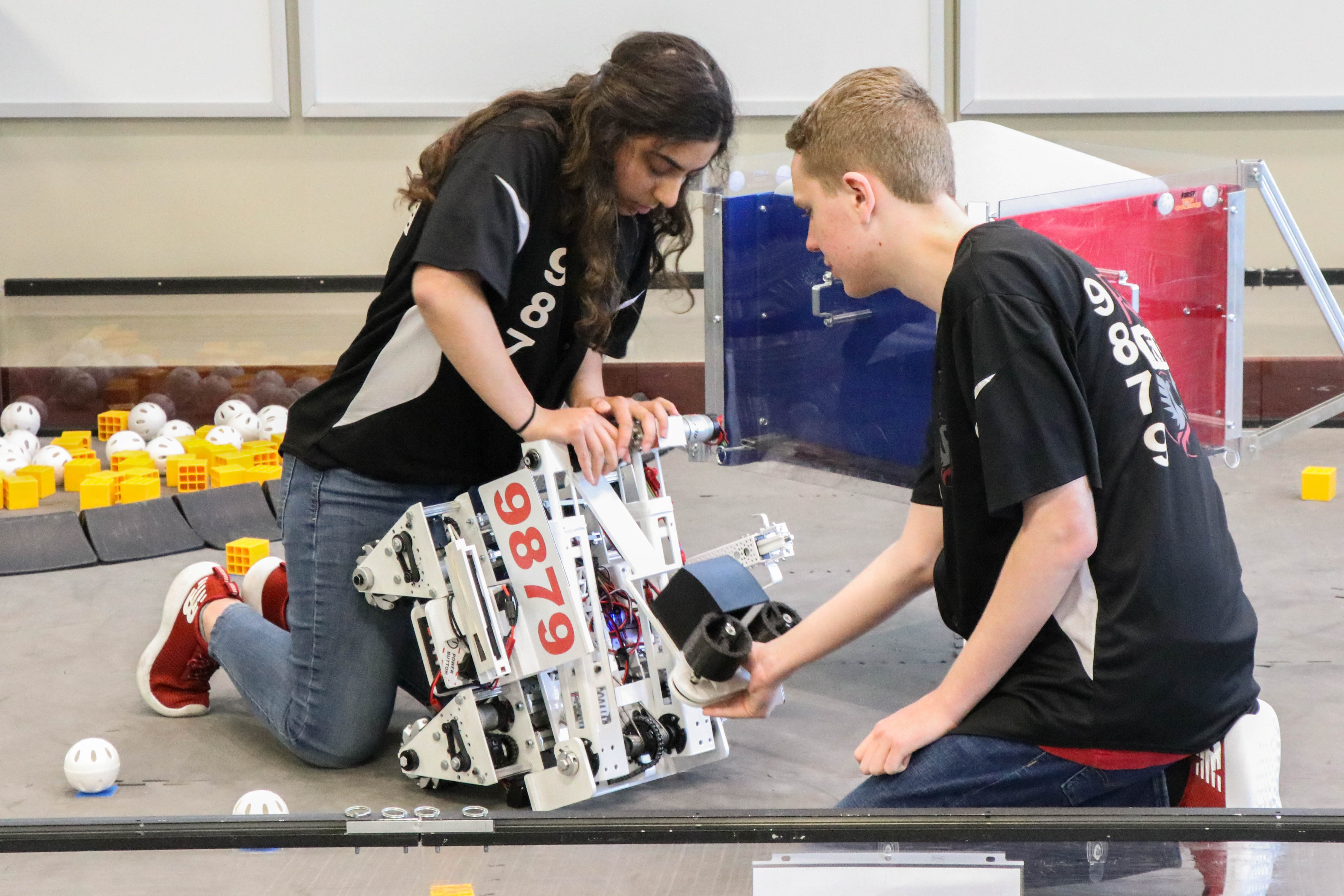 Photo of two students with a robot.