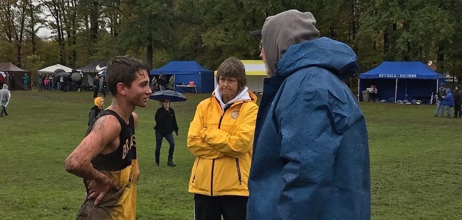 A runner with Craig Sluga, Head Coach & Karen Barringer, Assistant Coach