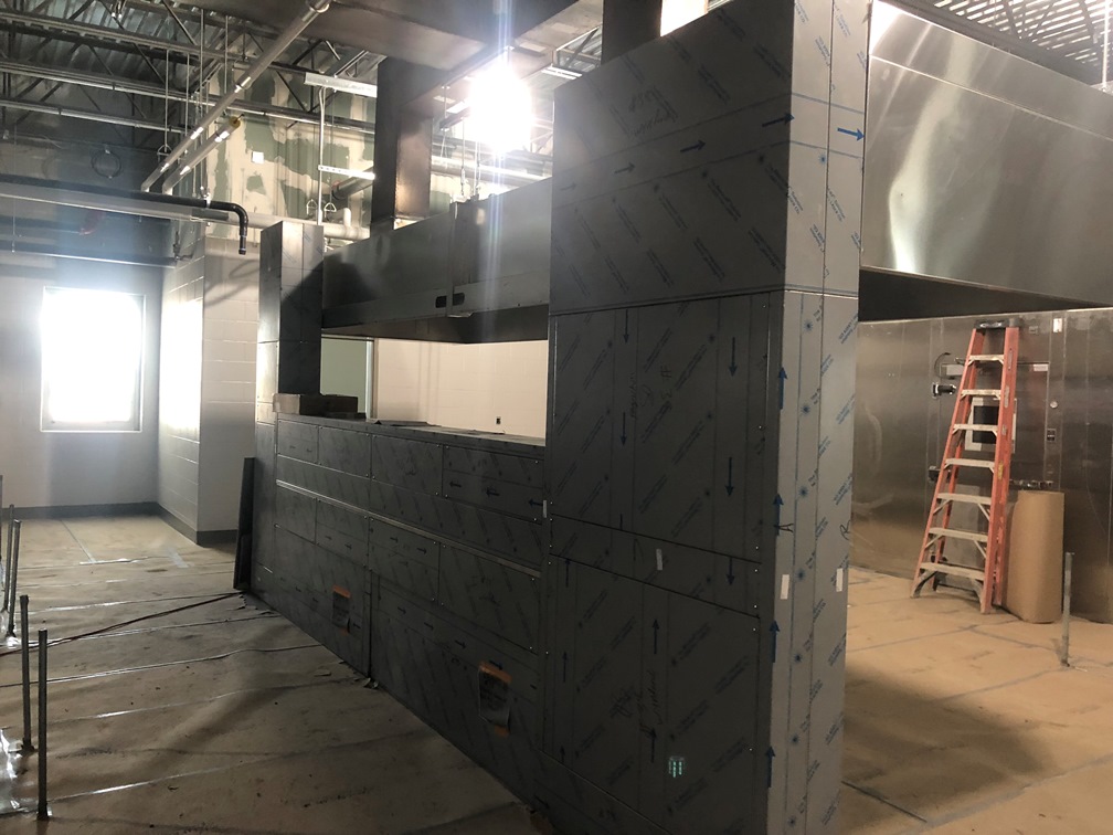 Photo of the Kitchen hood with new freezer and cooler in the background.