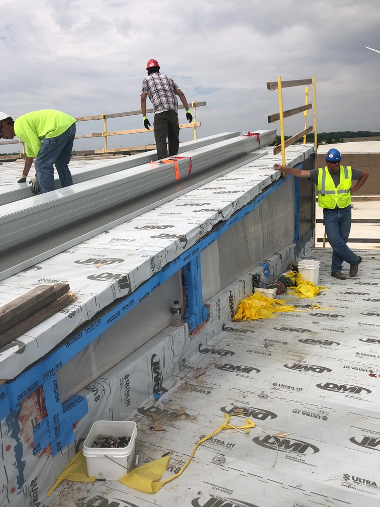 Photo of the roof metal is stacked, tied together, and ready for installation.