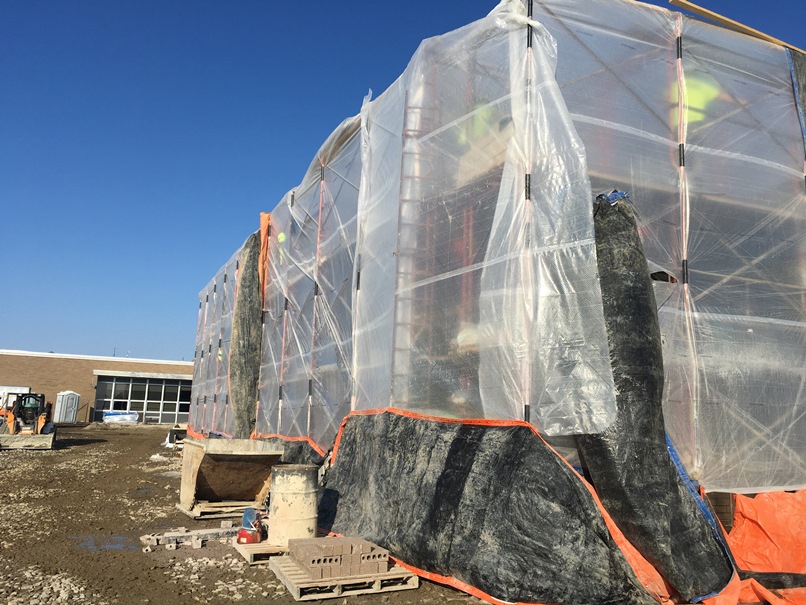 Photo of the west side of the building behind the gym - Block and brick being laid despite the cold and snow.
