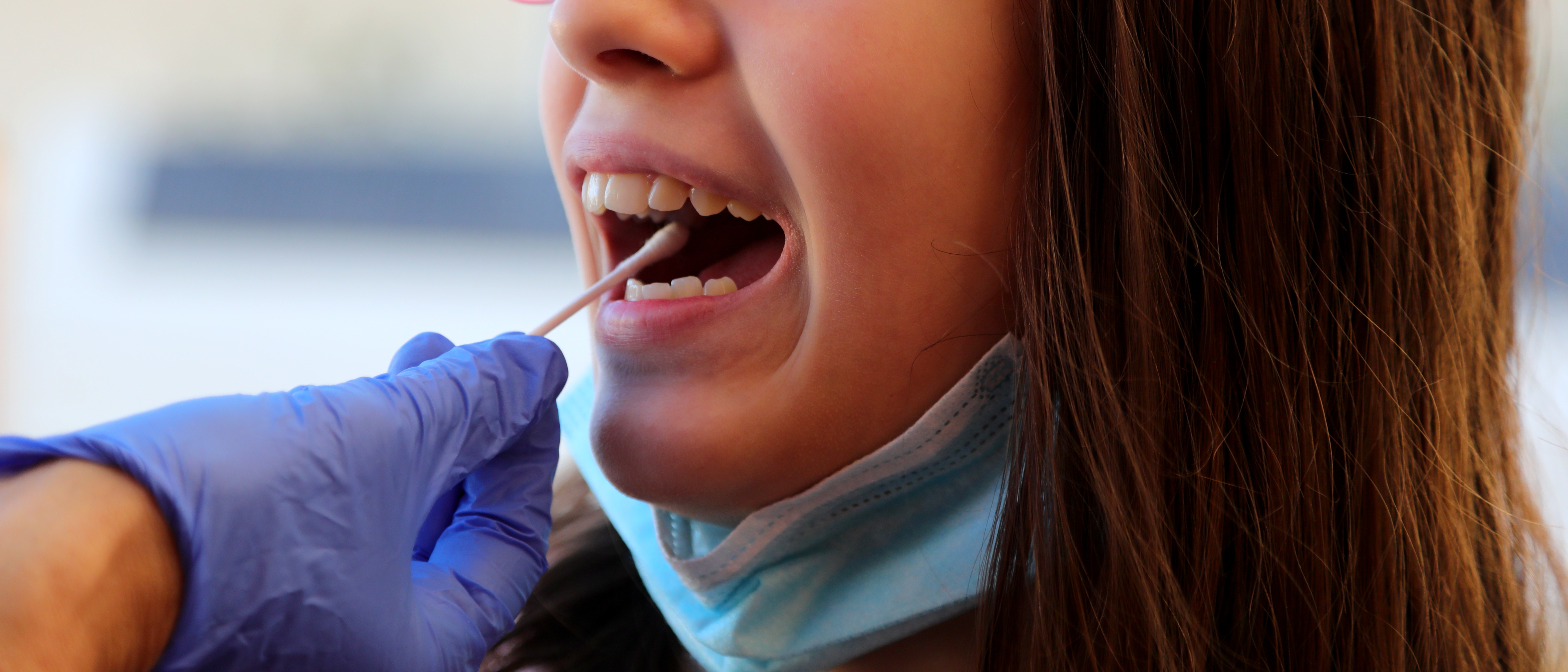 Girl getting her cheek swabbed for COVID-19 testing