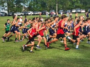 A photo of all the students in the Cross Country club running around the field.