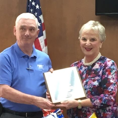 Outgoing President Jim Payne receiving a plaque for his service from Sallie Lipsey, incoming President