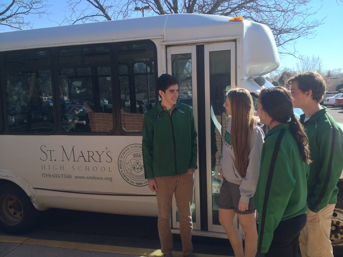 Students standing in front of a school bus