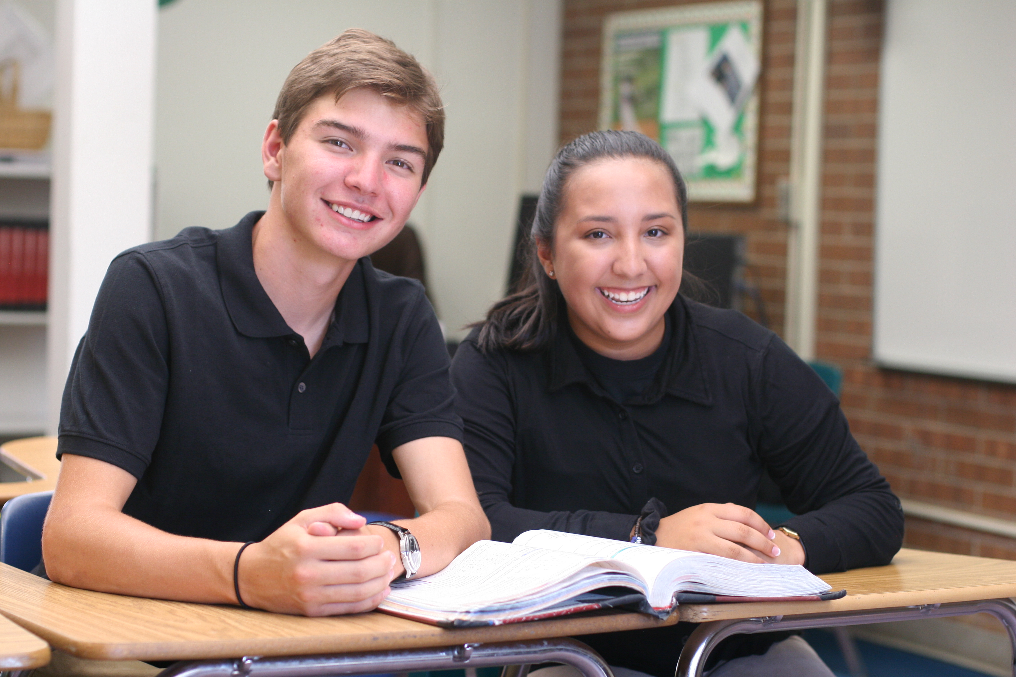 2 students posing at their desk