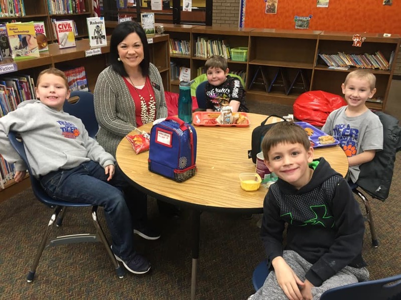 A photo of the principal having lunch with a group of students