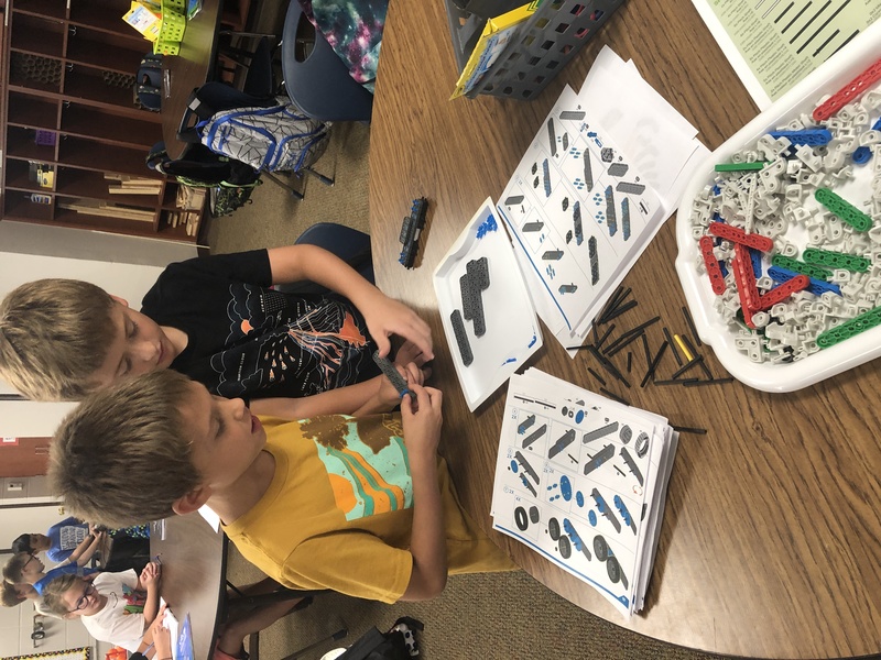 Photo of two boys looking at a manual to build a Lego