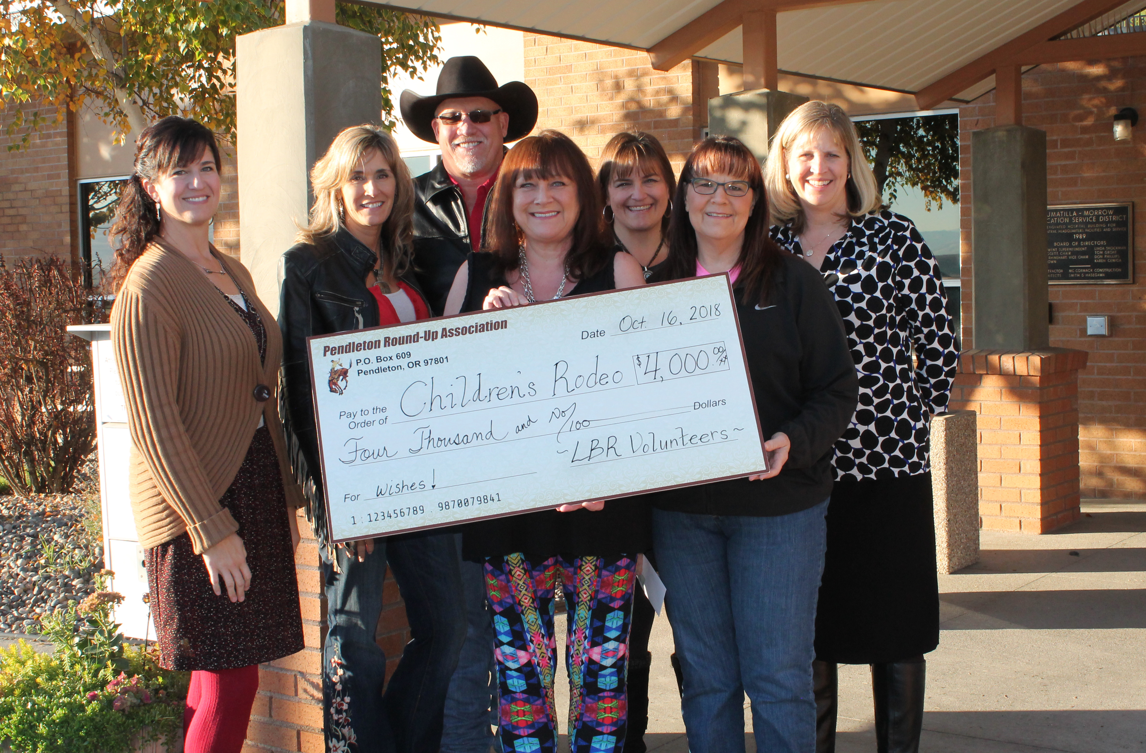 From left, Chrissy Nelson (IMESD), Jill Ledbetter and Mike Ledbetter (Round-Up), Linda Smith, Char Surber, Karen Parker and Michele Madril (all IMESD) pose with the donation check from Let ‘er Buck Room volunteers.