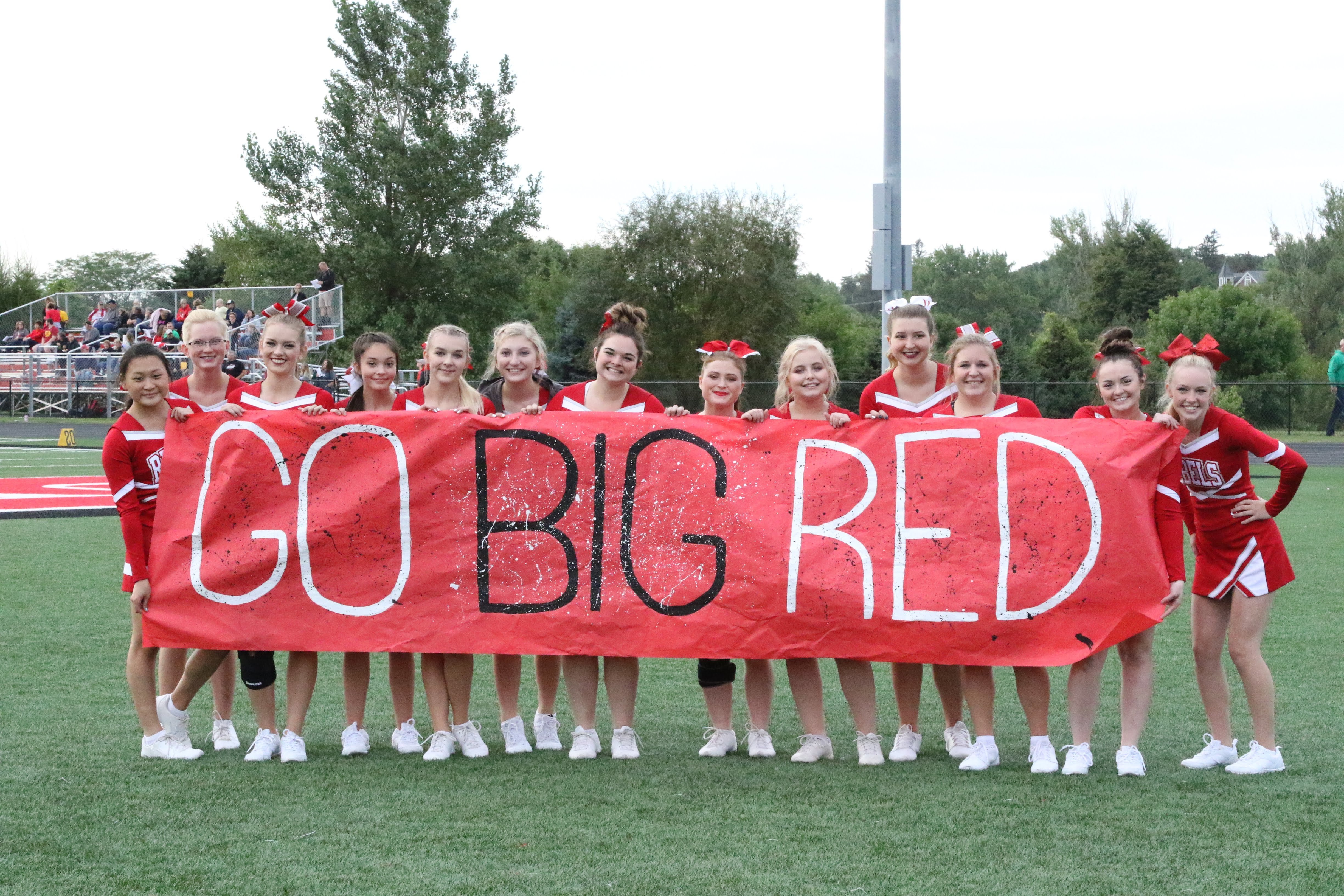 Cheerleaders with a "Go Big Red" sign