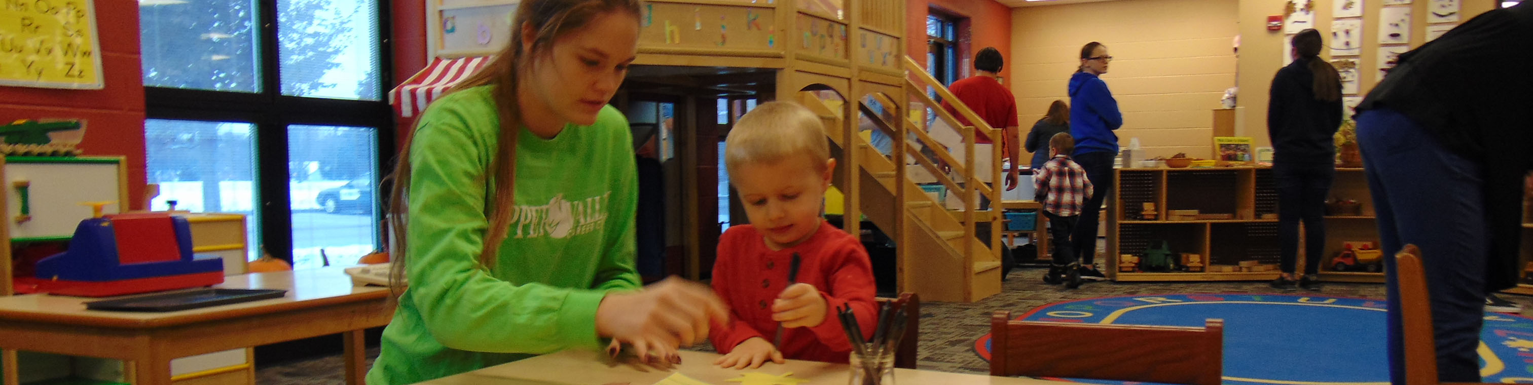 Student working with preschool child