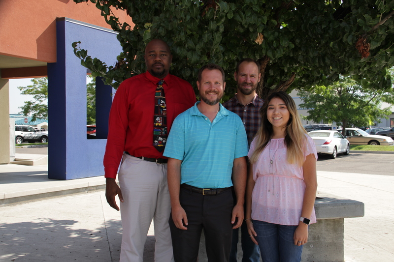 The IT team standing in front of a tree