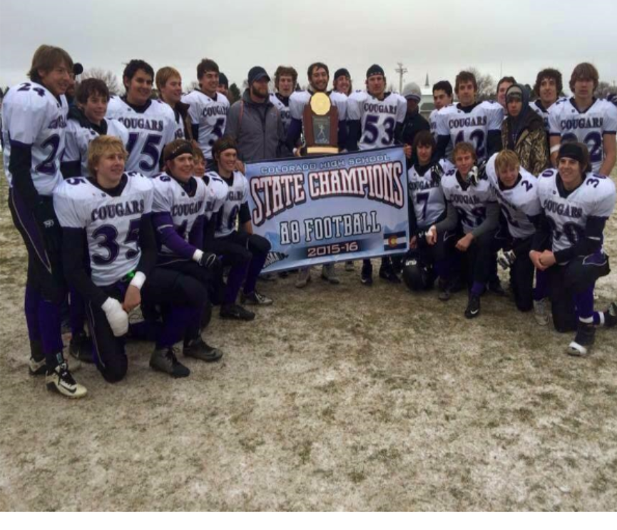 Football player holding a state championship banner