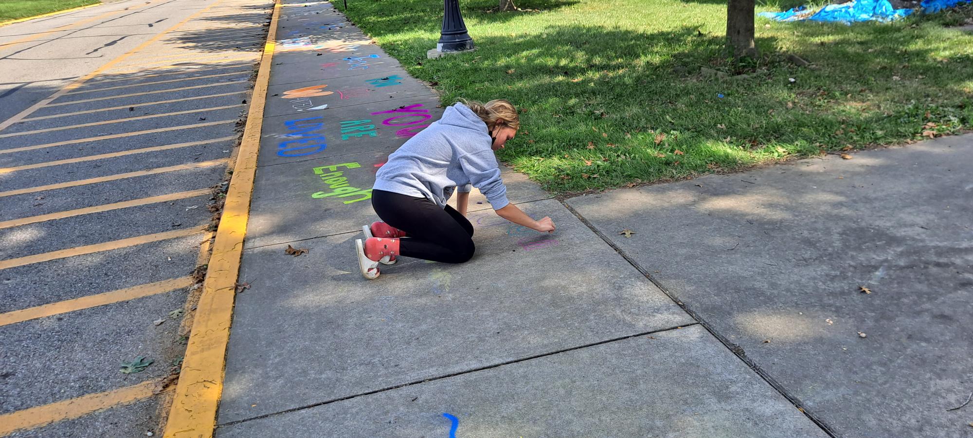 girl drawing on sidewalk