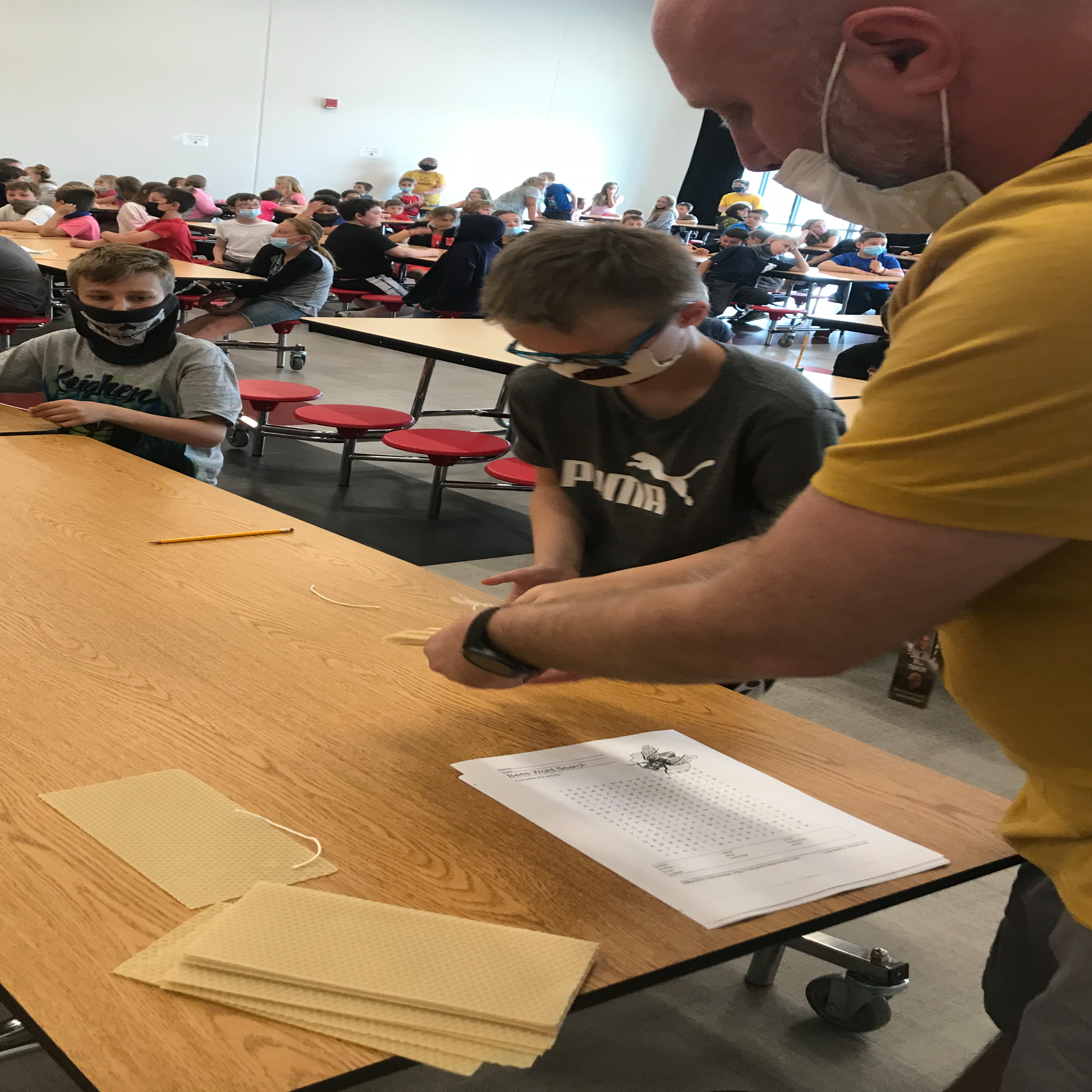 Mr. Tisron helping student make wax candles.