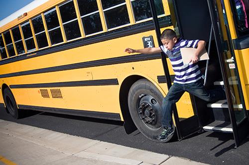 Photo of a student going down a school bus.