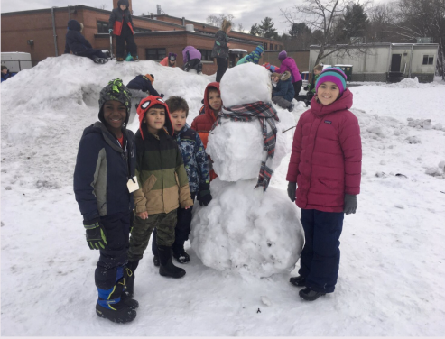 Students building a snowman
