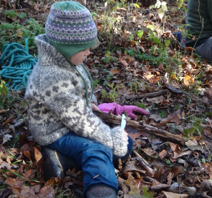 child practices carving with a butter knife