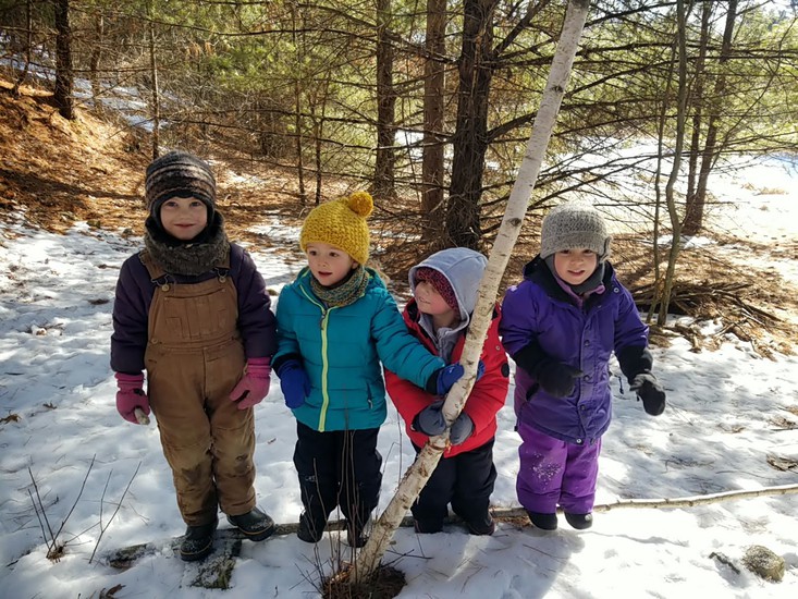 children standing in a group against a snowing landscape
