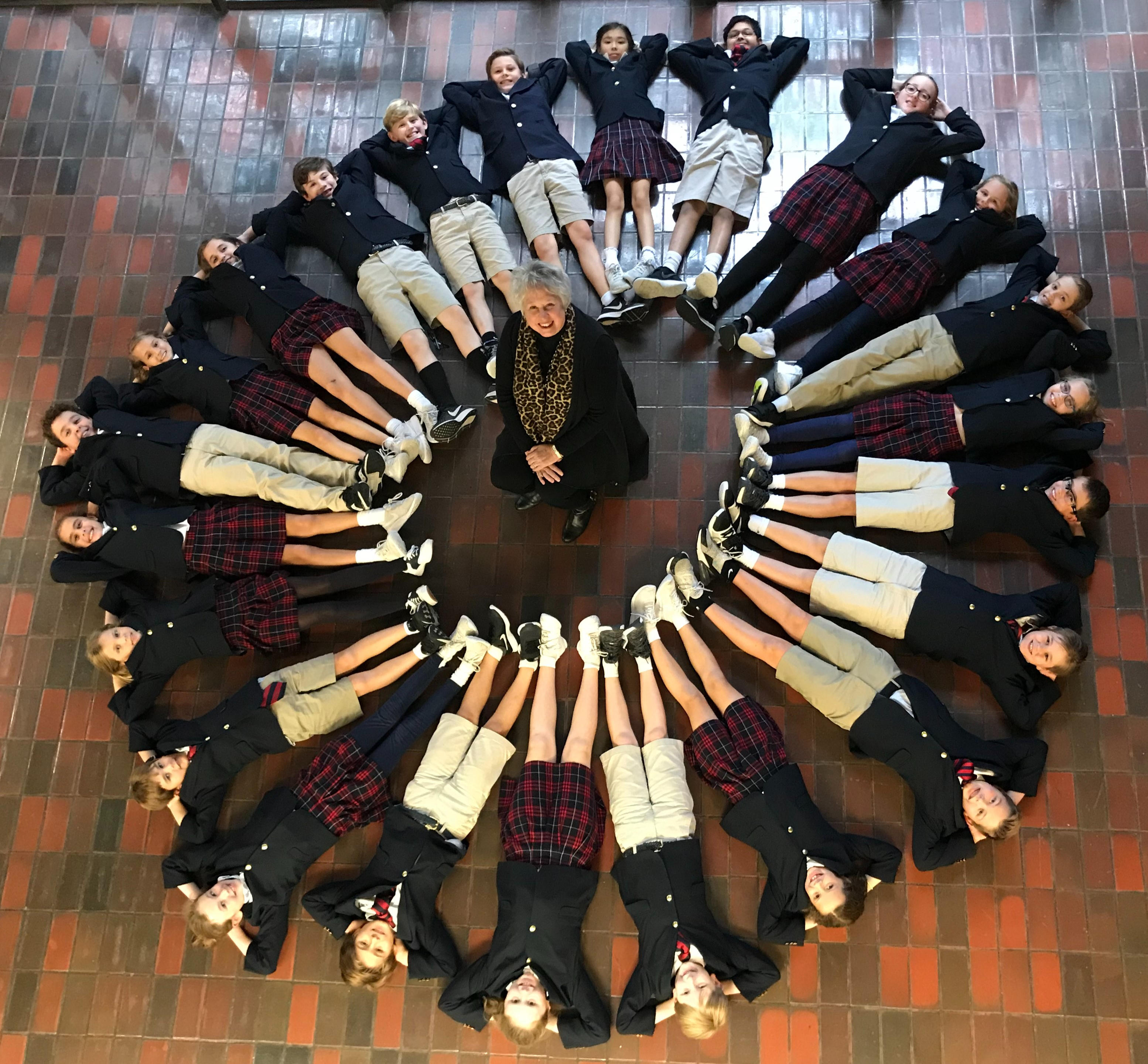 CIRCLE OF ELEMENTARY STUDENTS AND MISS LINDA