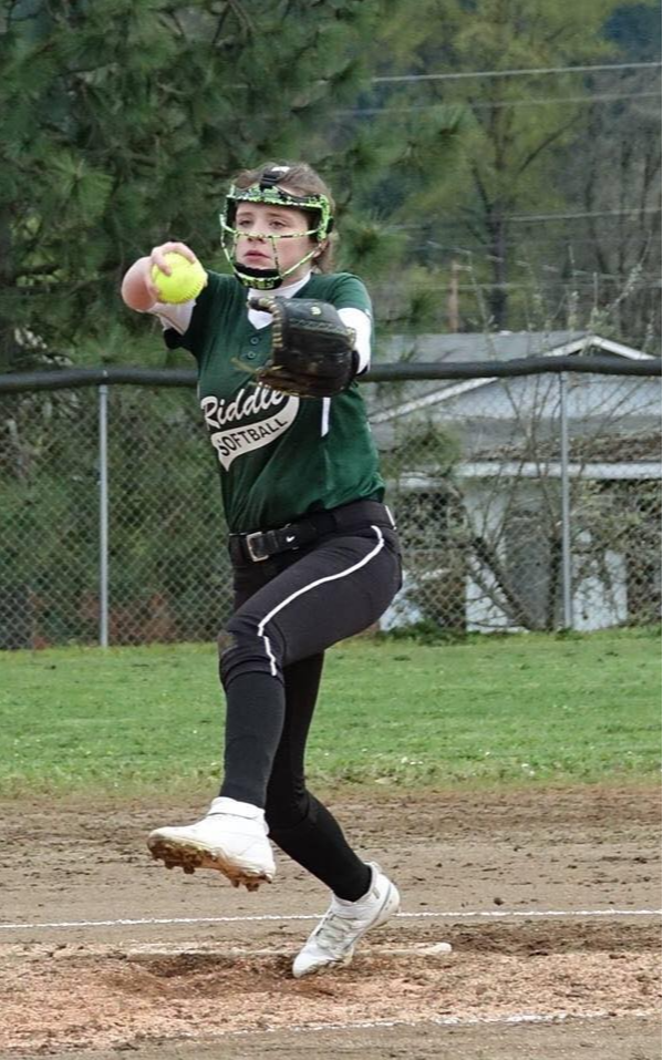 Softball player pitches at the mound