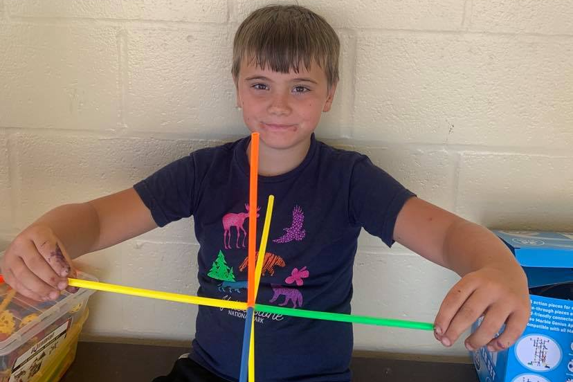 Students poses with creation at camp.