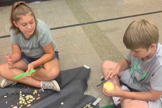 Campers making Apple Head Dolls.