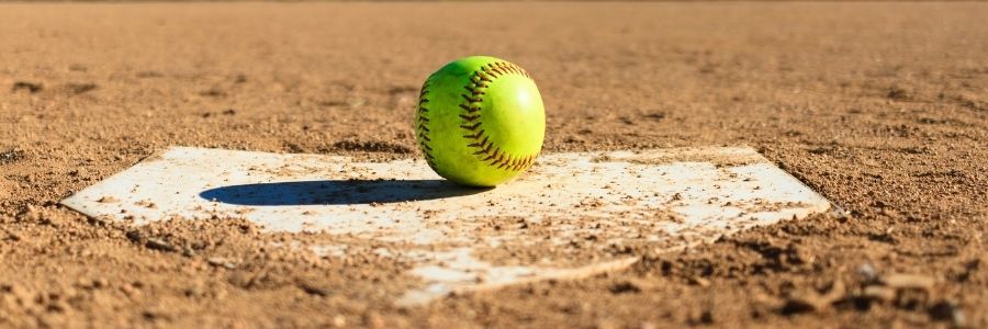 Picture of a softball field with a base and yellow softball