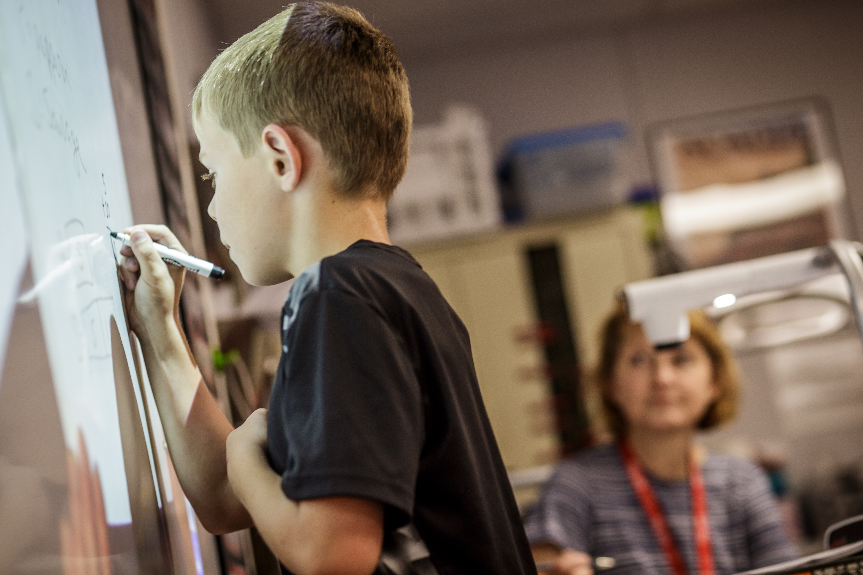 Student at a whiteboard writing.