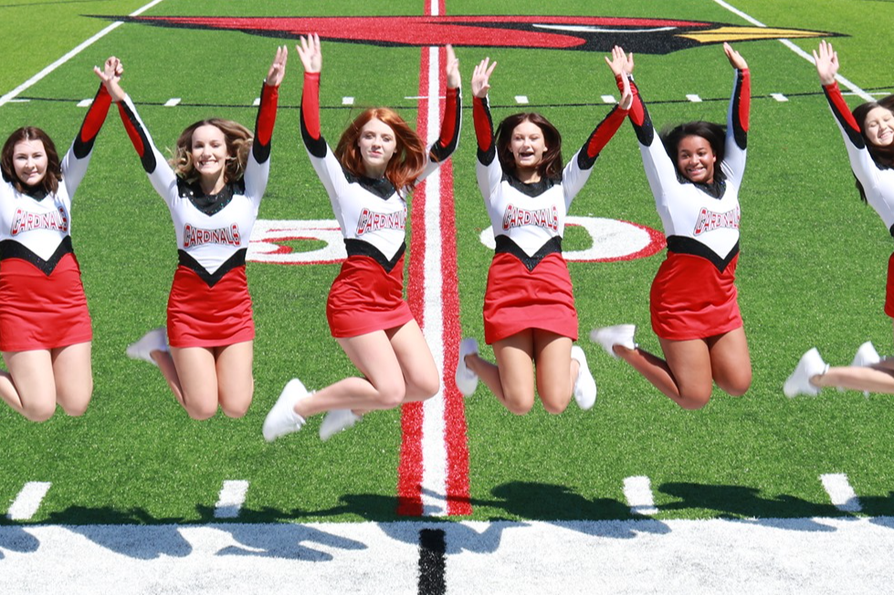 dance team jumping on football field