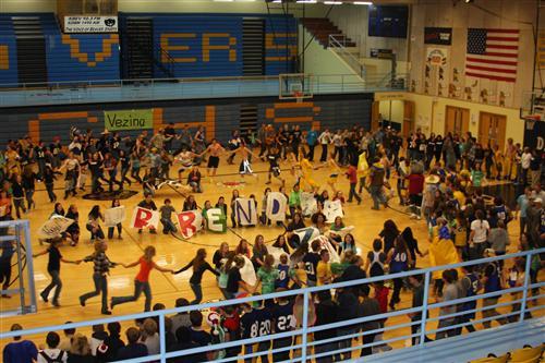 A photo of students playing a game at a pep rally in the gym