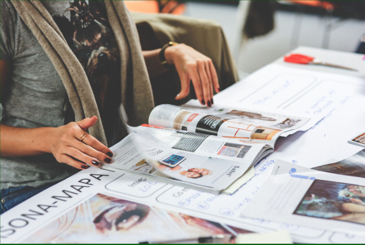 A woman looking at a series of magazines